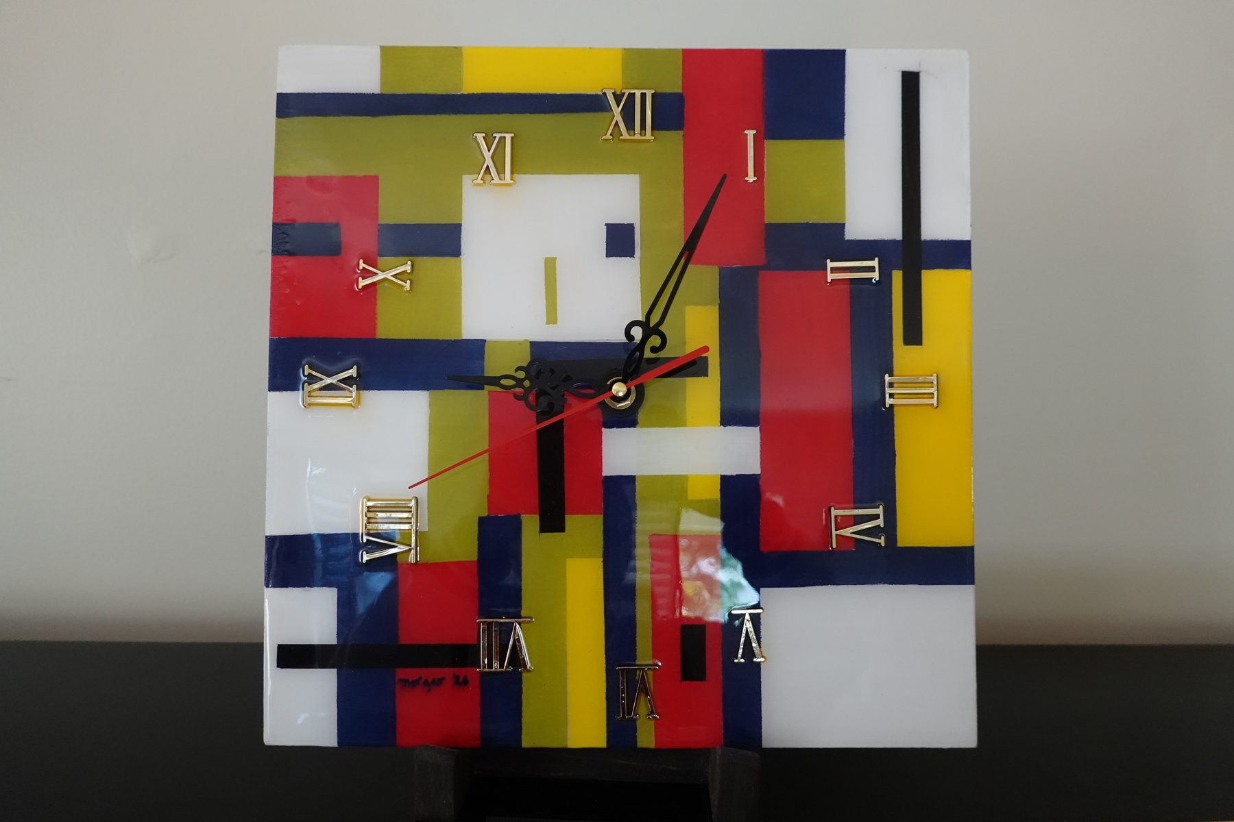 Primary Grid, an abstract geometric wall clock with a Mondrian-inspired painted background in red, blue, yellow and white